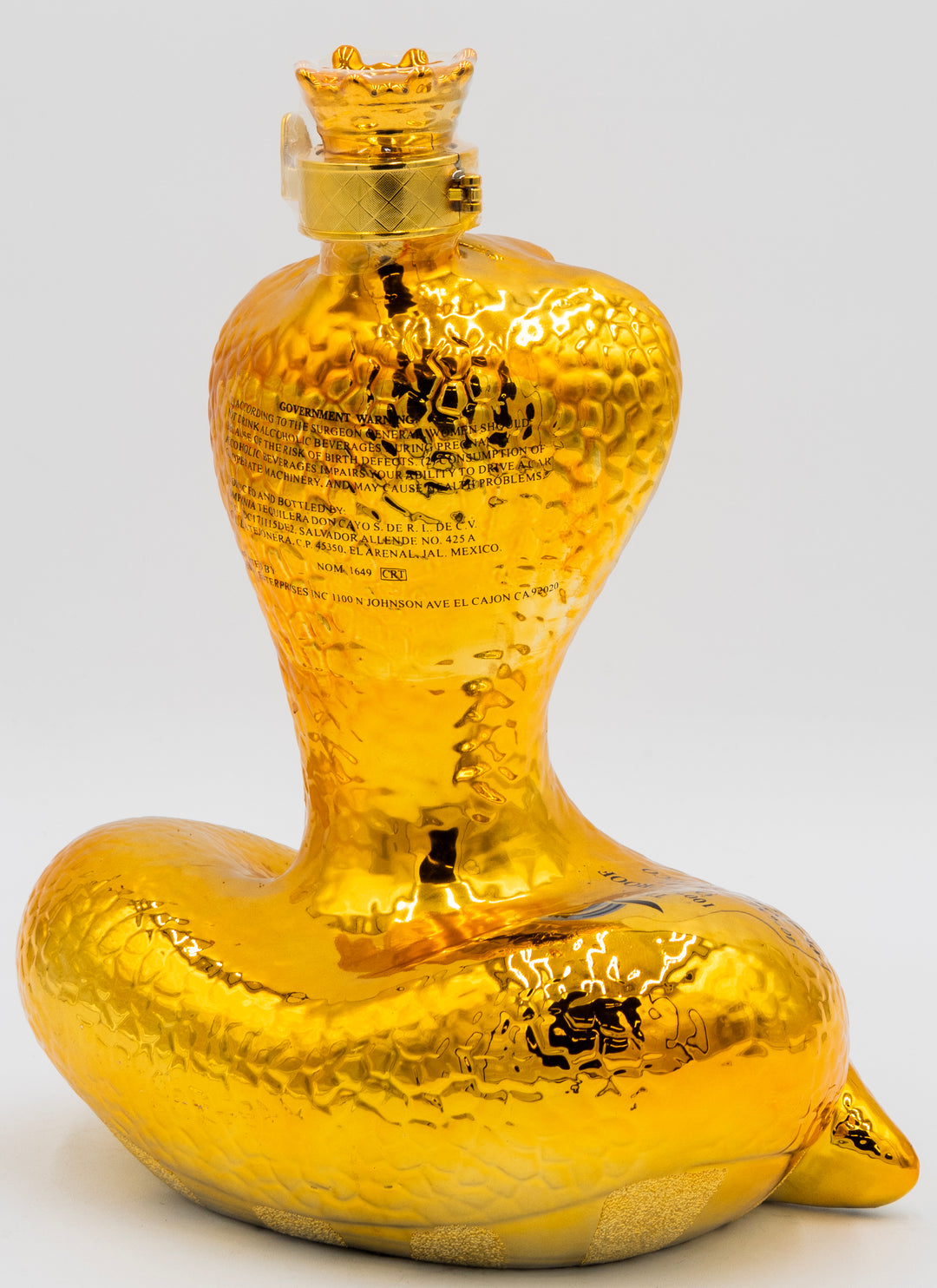 Gold-colored bottle with unique design on a gray background