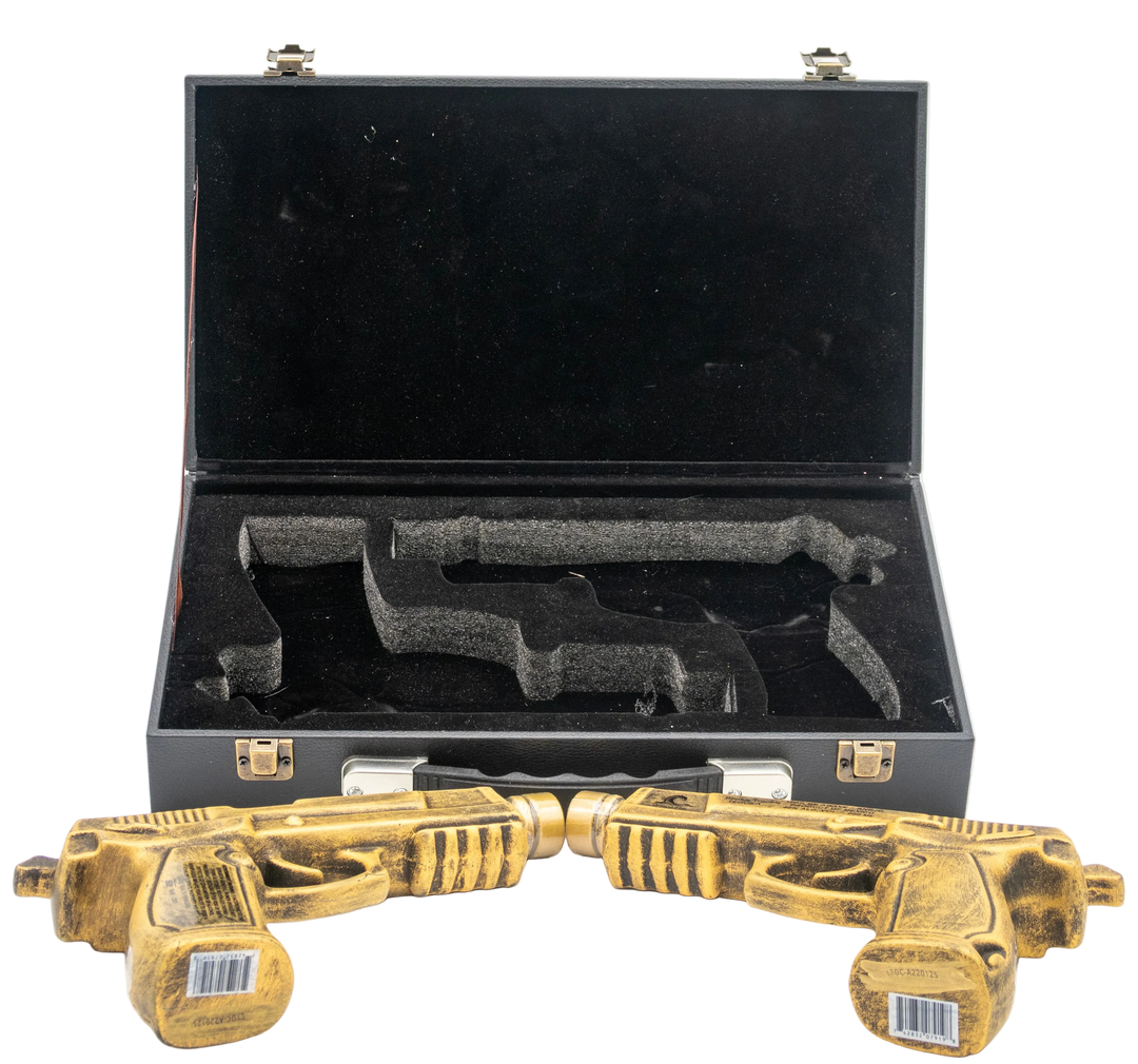 Two gold toy guns in front of an open black case on a white background.