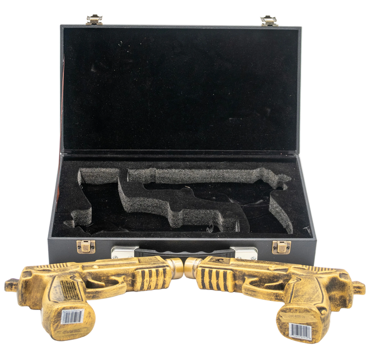 Two gold toy guns in front of an open black case on a white background.