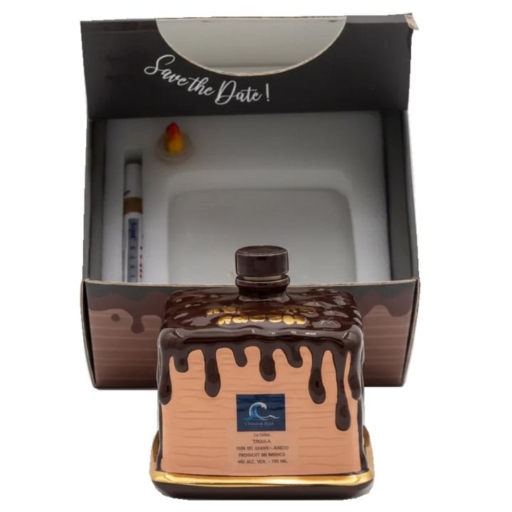 Oceano Azul square chocolate-colored La Cake bottle in front of its open presentation box and accessories.