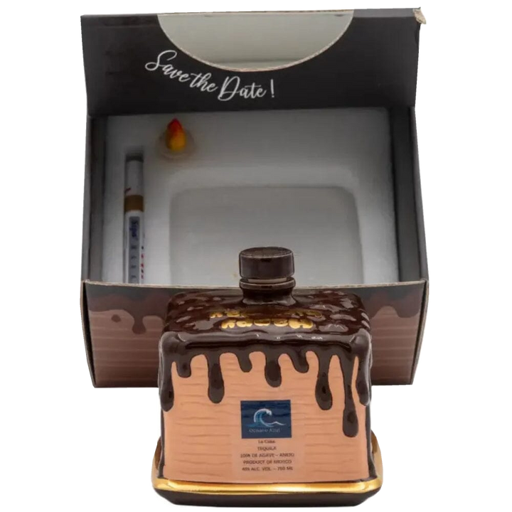 Oceano Azul square chocolate-colored La Cake bottle in front of its open presentation box with included accessories.