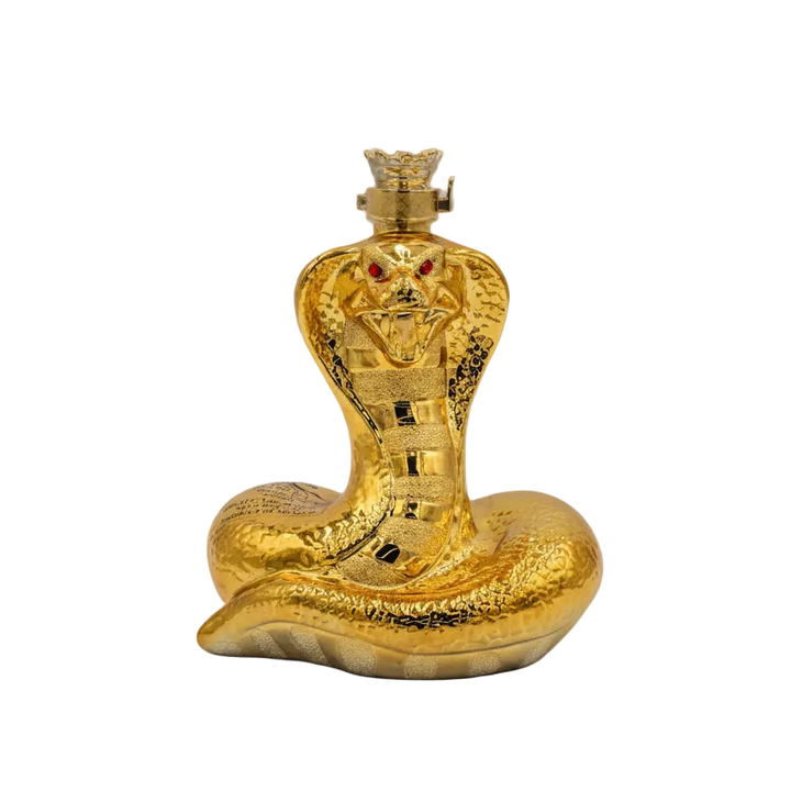 A sculptural bottle of Oceano Azul Golden Snake Añejo Tequila, featuring a coiled golden snake design with red eyes on the cap