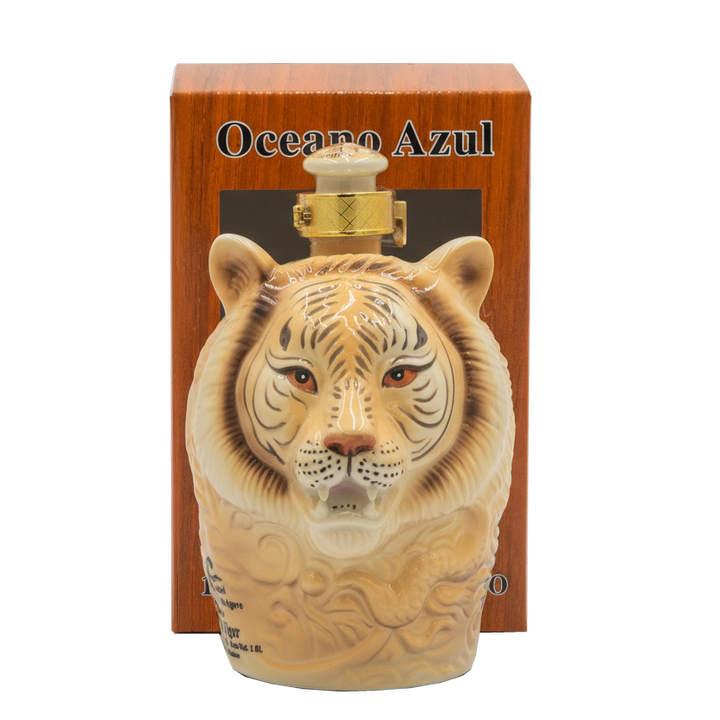 Oceano Azul White Tiger Anejo Tequila ceramic bottle displayed in front of its orange presentation box.