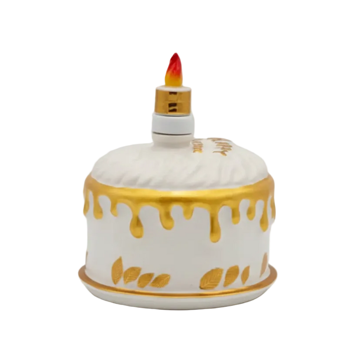 Oceano Azul round white La Cake bottle with gold decorations and candle-shaped stopper.