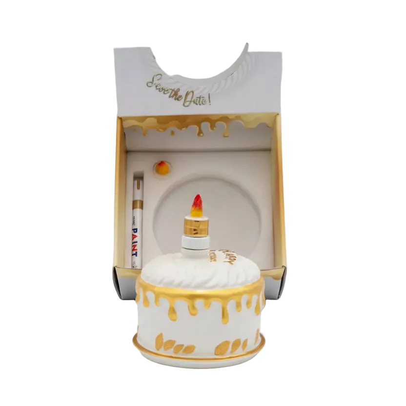 Oceano Azul round white La Cake bottle in front of its open presentation box and accessories.