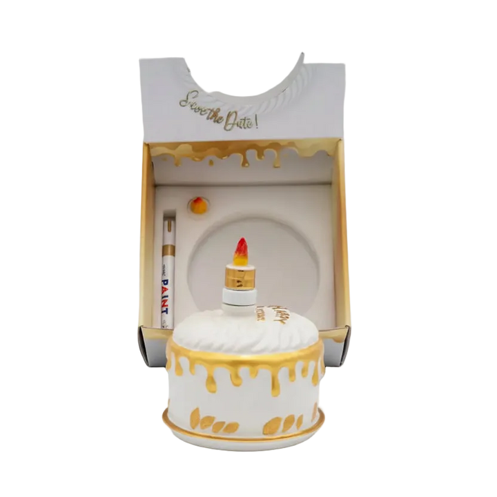 Oceano Azul round white La Cake bottle in front of its open presentation box and accessories.