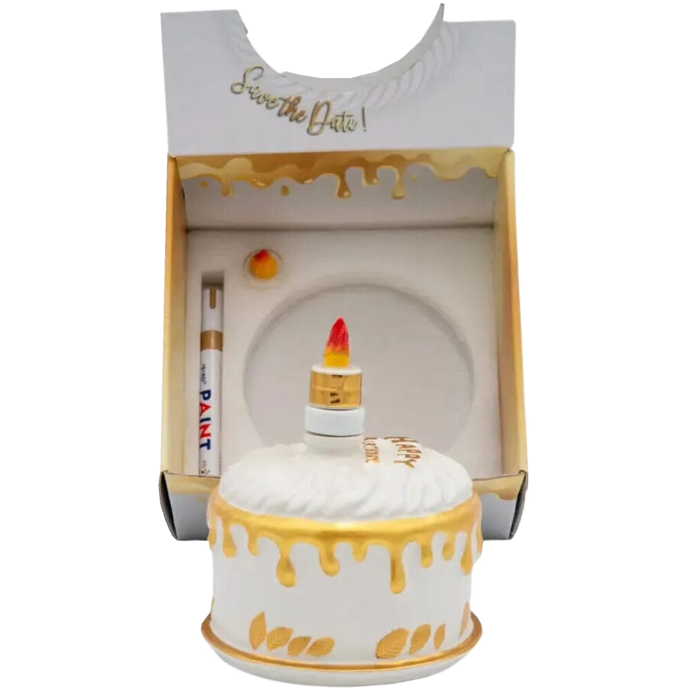 Oceano Azul Round White La Cake vodka bottle in front of its open presentation box with included accessories.